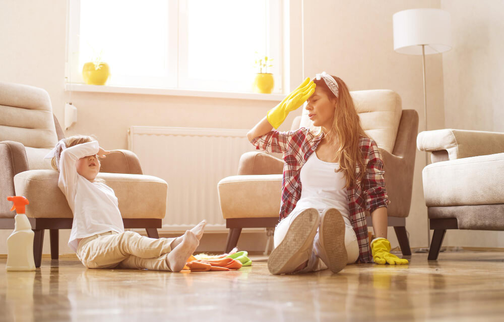 mother-daughter-feeling-exhausted-after-cleaning-home-together 